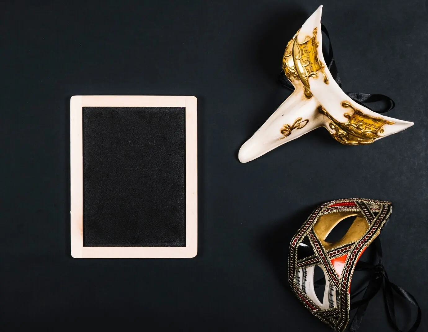Elegante Masken in der Nähe einer Kreidetafel